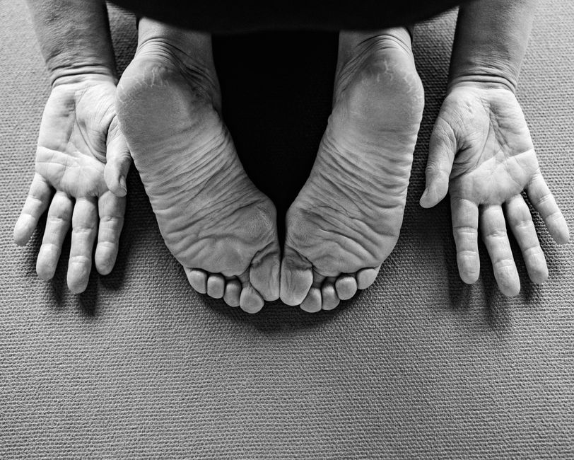 Hands pressing into a well-worn mat.